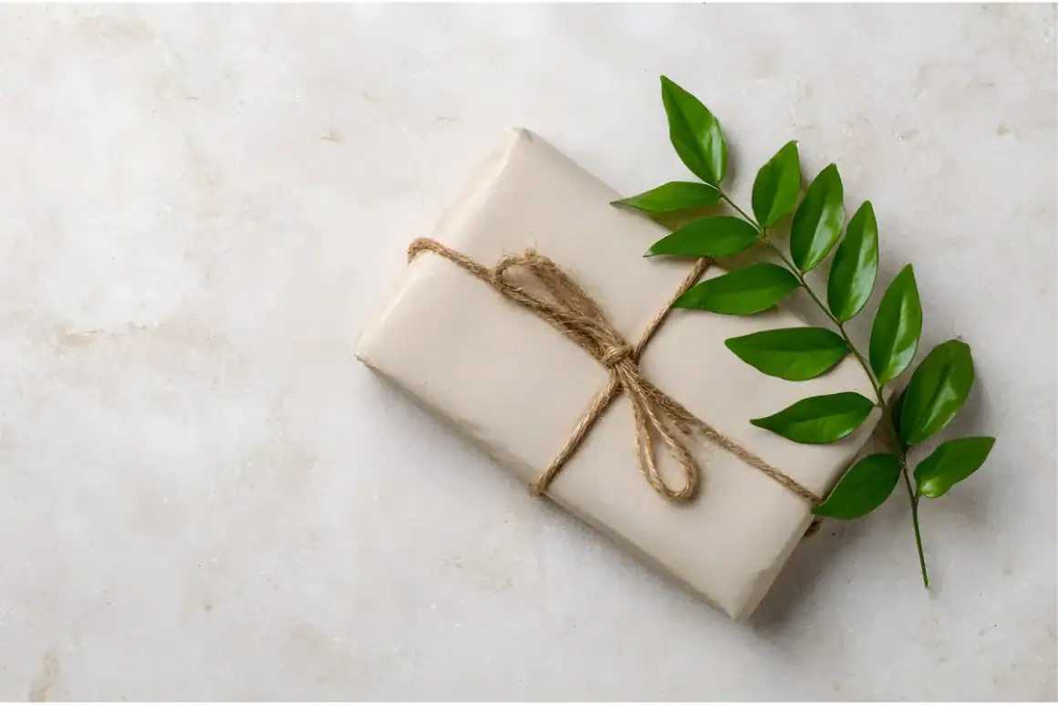 A single gift wrapped in soft beige paper and tied with natural twine, accented by a green sprig — symbolizing intentional, mindful connection.