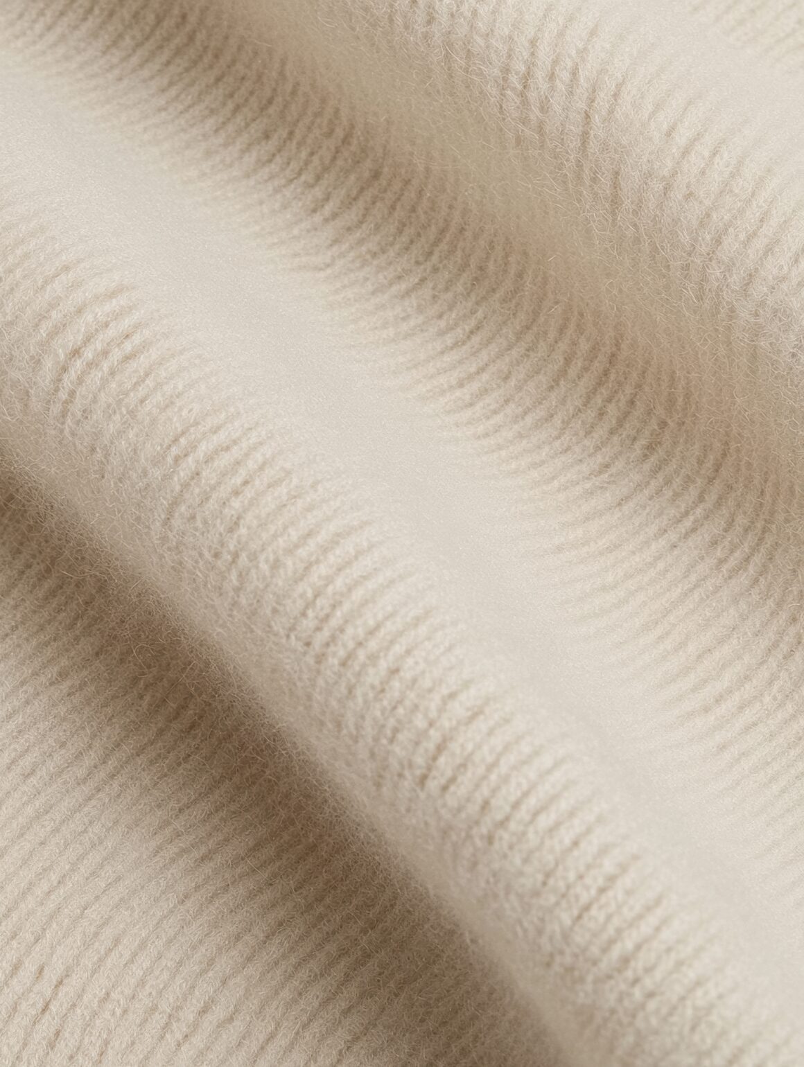 Soft beige textured fabric with smooth, cozy surface, perfect for luxurious home decor and interior design.