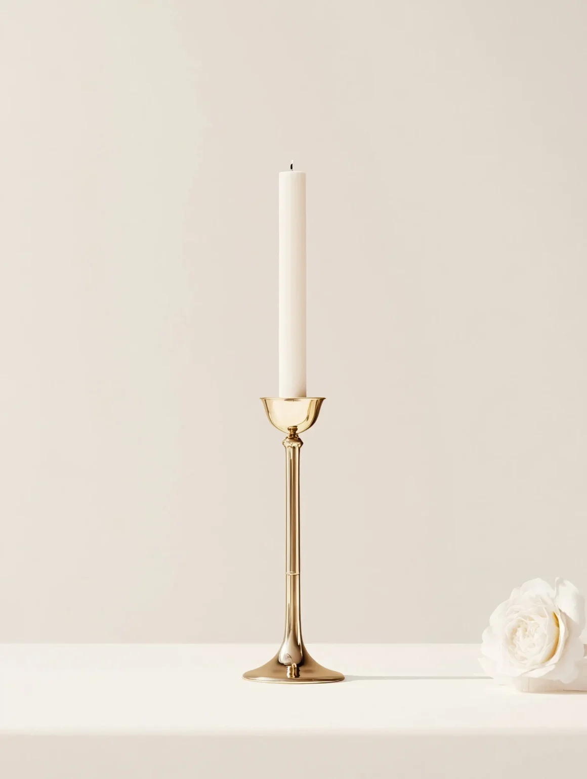 Single taper candle in a brass candleholder against a neutral backdrop, demonstrating the daily ritual use of candles vs electric light.