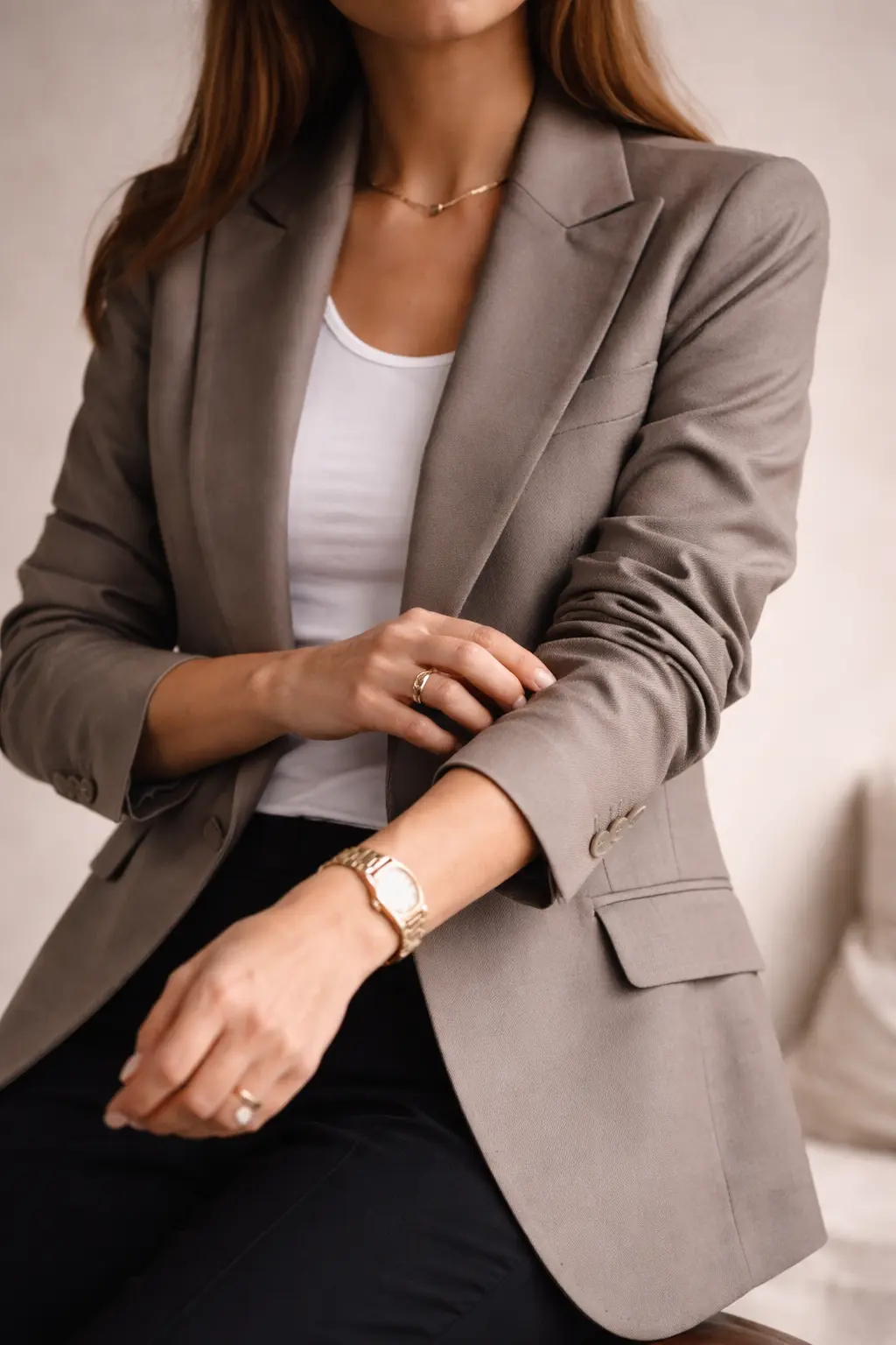 Woman adjusting blazer sleeve, showing professional style without stiffness.
