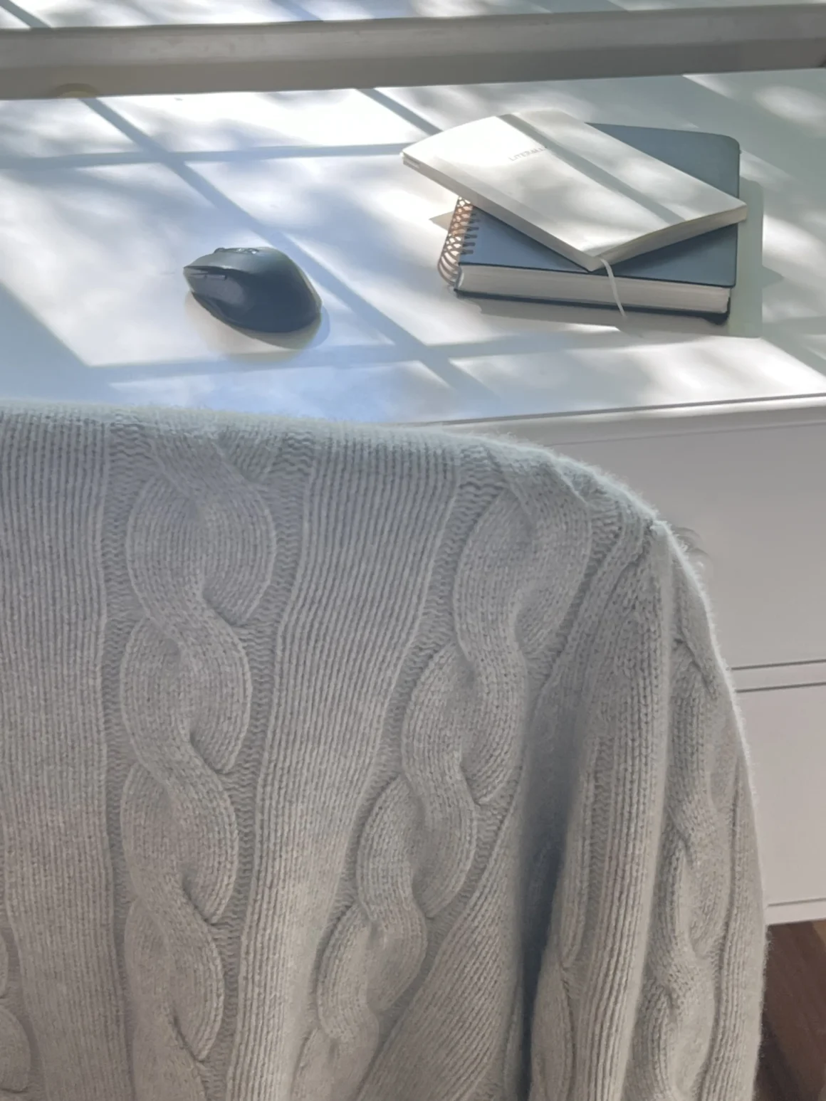 Quince cashmere cardigan draped over a chair in soft morning light, for the wearer, is a key piece in repeating outfits.
